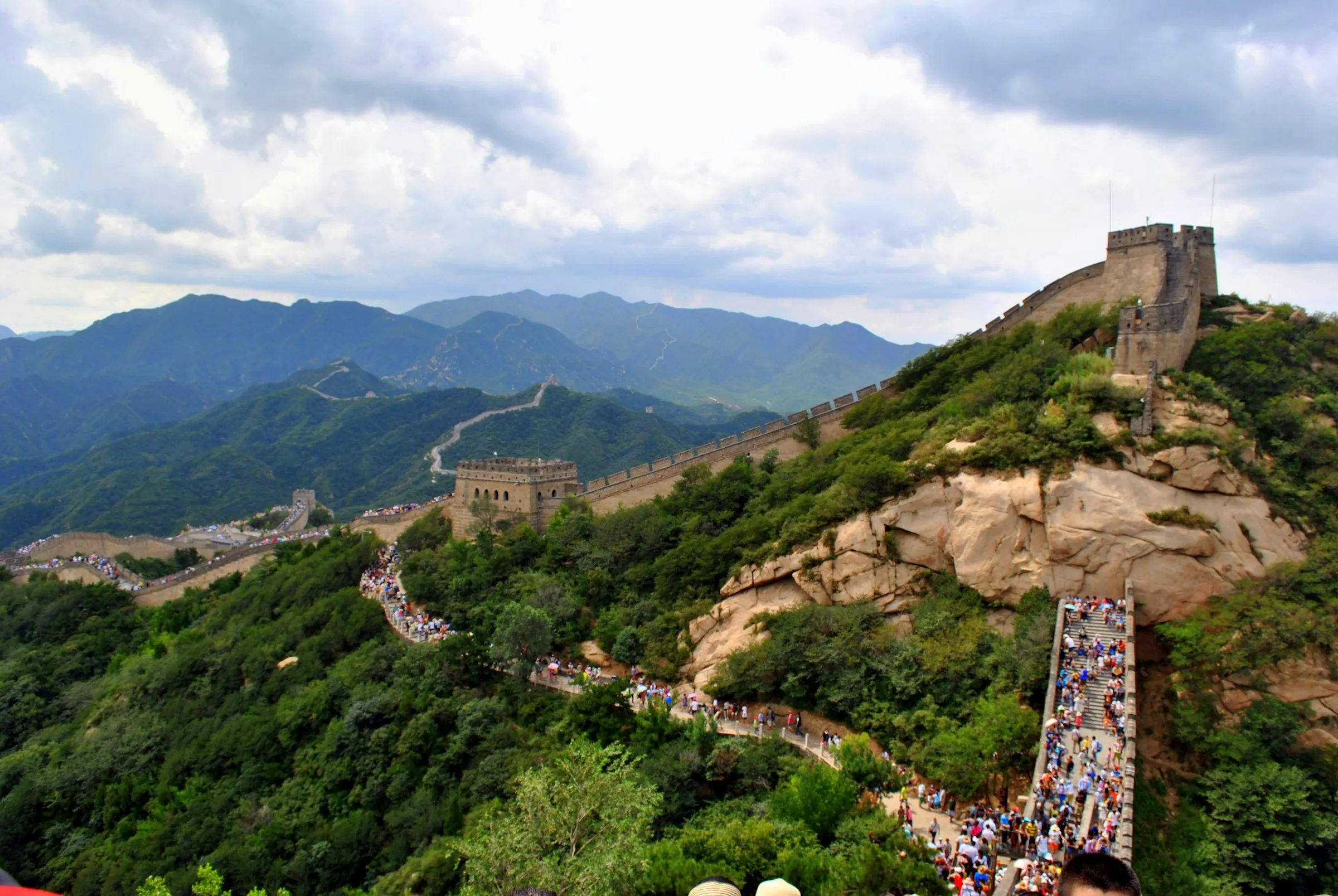 Visitors on the stepped wall at Badaling below a large watchtower